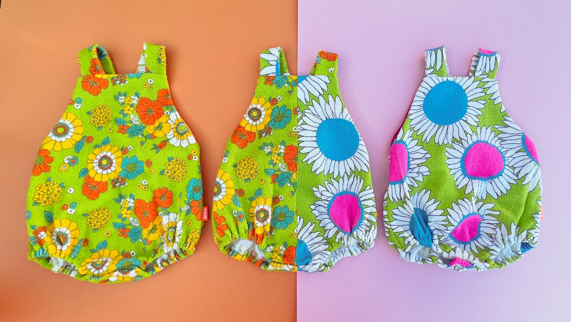 Three colorful children's rompers with floral patterns on a split background.